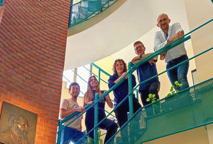 Dr Ruben Quintana-Cabera and his team in France standing on a staircase in their institute 
